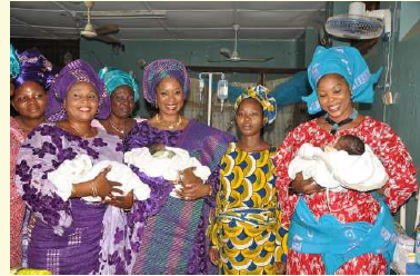 Mrs. Amosun presenting gifts to a mother of triplets